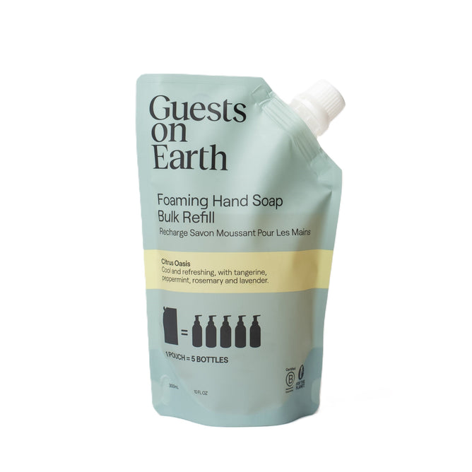 The Guests on Earth Foaming Hand Soap Bulk Refill pouch in blue-green offers a Citrus Oasis scent of tangerine, peppermint, rosemary, and lavender. It equals five bottles and pairs with reusable vessels, complete with a white cap for convenient use.