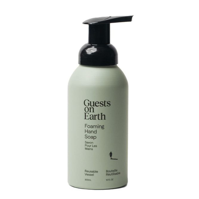 A Guests on Earth Citrus Oasis foaming hand soap features a green bottle with a black pump, and bears bilingual English and French text on its label about its reusability.
