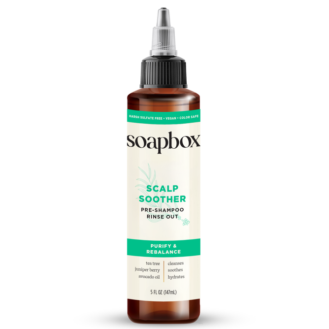 A 5 fl oz (147 mL) white plastic bottle labeled Soapbox Scalp Soother Rebalancing Rinse-Out with a black twist-open cap. This sulfate-free, vegan, color-safe pre-shampoo treatment features tea tree, juniper berry, and avocado oil.