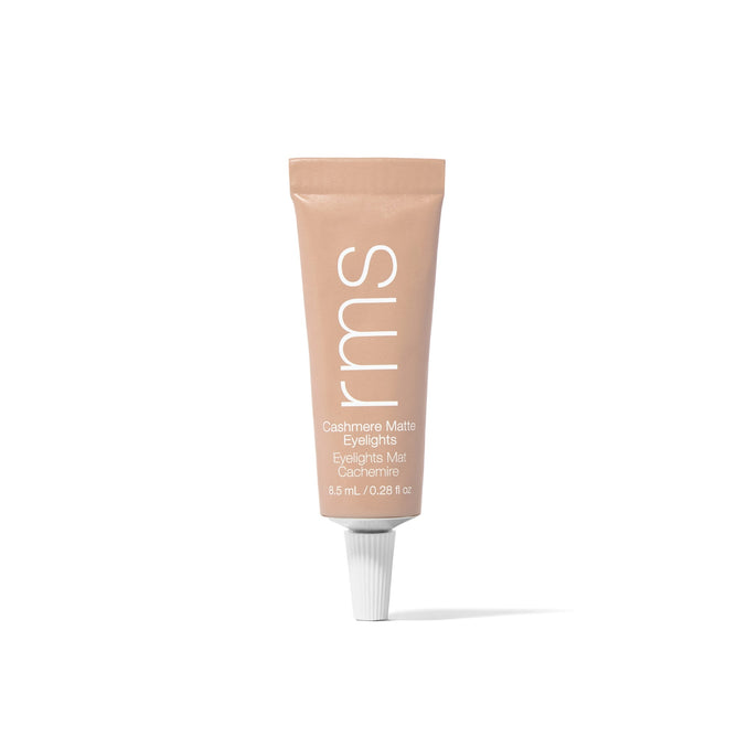A beige tube of RMS Beauty Cashmere Matte Eyelights stands upright on a white background. It features a white cap, with the product name and details printed in white on the tube.