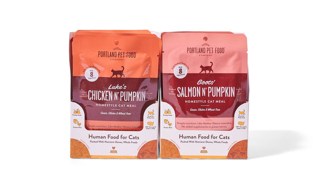 Two 2.6 oz pouches from Portland Pet Food Companys Cat Meal Variety Pack are shown: Lukes Chicken N Pumpkin and Boots Salmon N Pumpkin. These homestyle wet puree meals use natural, human-grade ingredients, and are grain-, gluten-, and wheat-free.