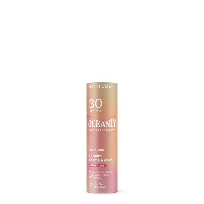 A cylindrical tube of ATTITUDE Oceanly PHYTO-SUN Lip Balm SPF30 in pink and gold gradient packaging, labeled Plastic Free Beauty, featuring mineral sunscreen info in English and French.