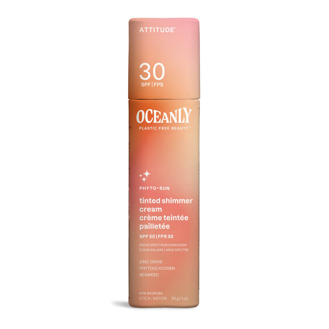 Oceanly PHYTO-SUN Tinted, Shimmer Face Sunscreen Cream SPF 30 by ATTITUDE comes in pink and beige plastic-free packaging with white text. This mineral glitter cream features zinc oxide, phytoglycogen, seaweed, and vegan collagen substitute.