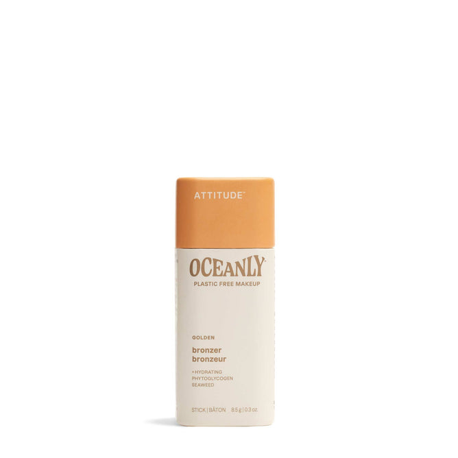 An upright stick of ATTITUDE Oceanly Bronzer, in a golden shade and housed in a beige-orange rectangular tube, is displayed against a plain white background.