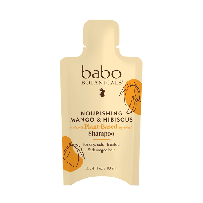 A beige packet of Babo Botanicals Nourishing Shampoo for Dry, Damaged Hair - Sample, featuring plant-based ingredients like mango butter and hibiscus flower, with orange mango illustrations. Suitable for color-treated hair.