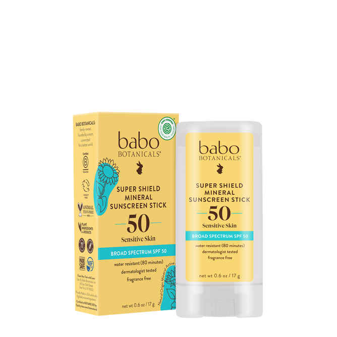 A yellow Babo Botanicals Super Shield Mineral Sunscreen Stick SPF50 and its matching box stand upright on a white background, highlighting natural origin zinc oxide for sensitive skin.