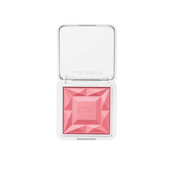 An open white compact reveals RMS Beautys ReDimension Hydra Powder Blush: a geometric, faceted pink powder with rms embossed at the center and RMS Beauty printed inside the lid. Crafted with skin-loving clean ingredients.