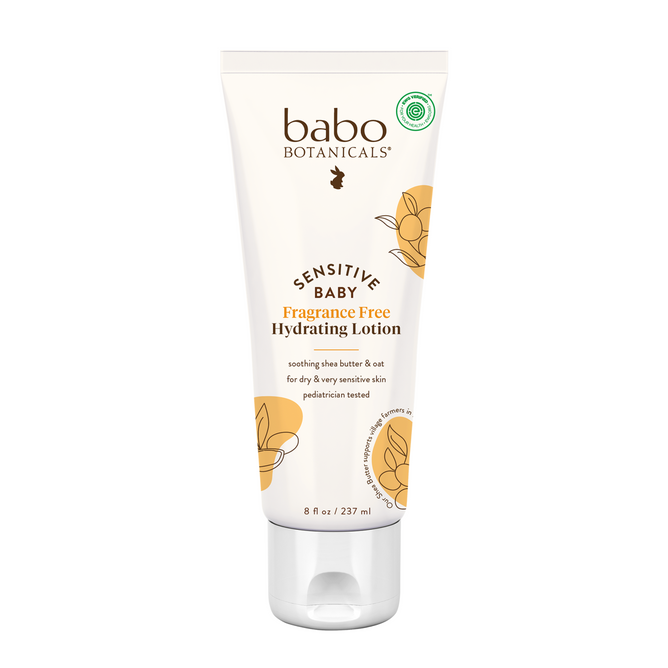 An 8 fl oz (237 ml) tube of Babo Botanicals Sensitive Baby Hydrating Baby Lotion, made with plant-based ingredients and shea butter. The white and beige tube has floral graphics and product details.