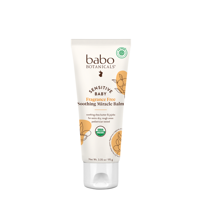 A tube of Babo Botanicals Sensitive Baby Soothing Miracle Balm, an organic balm featuring a white and beige design with flower illustrations and the USDA Organic Certified seal on the front.