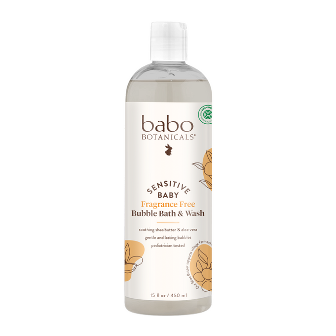 A 15 fl oz bottle of Babo Botanicals Sensitive Baby Bubble Bath & Wash, made with plant-based ingredients like shea butter and aloe vera, features light floral designs and product details on a white label.