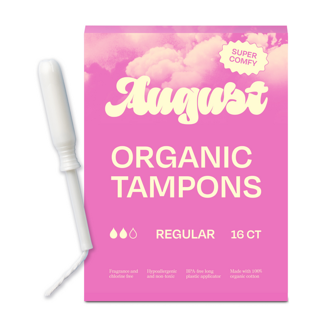 A pink box labeled August Regular Tampon features a “Super Comfy” cloud, includes a BPA-free applicator, and states it contains 16 regular absorbency organic cotton tampons made with hypoallergenic materials.