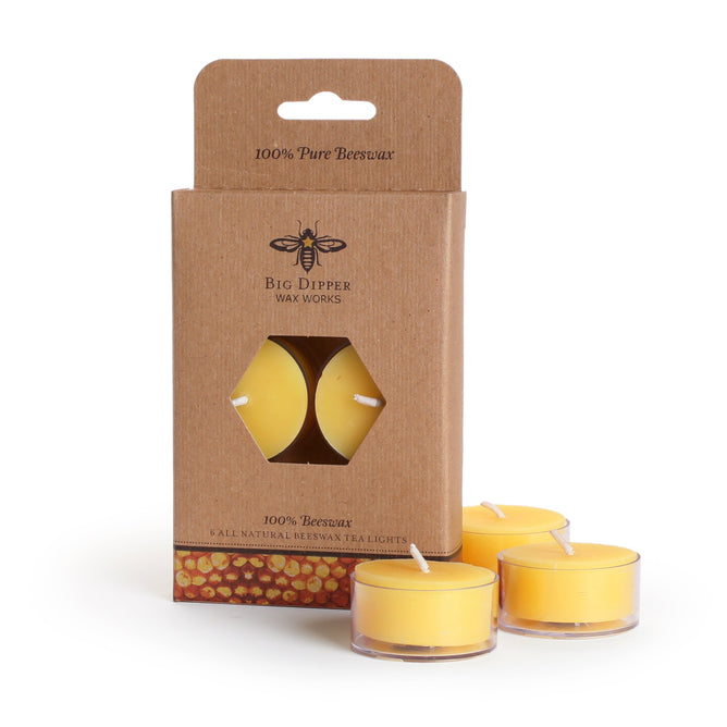 A box of Big Dipper Wax Works Pure Beeswax Tea Lights Natural includes six natural yellow tea lights, with three shown outside the brown packaging, providing a gentle aroma and warm glow to any room.