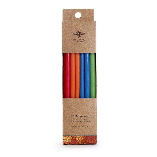 A 12-pack of Tall Birthday Tapers by Big Dipper Wax Works comes in an eco-friendly box with a bee graphic, labeled “100% Beeswax.” The assorted hand-dipped candles are visible through the window.