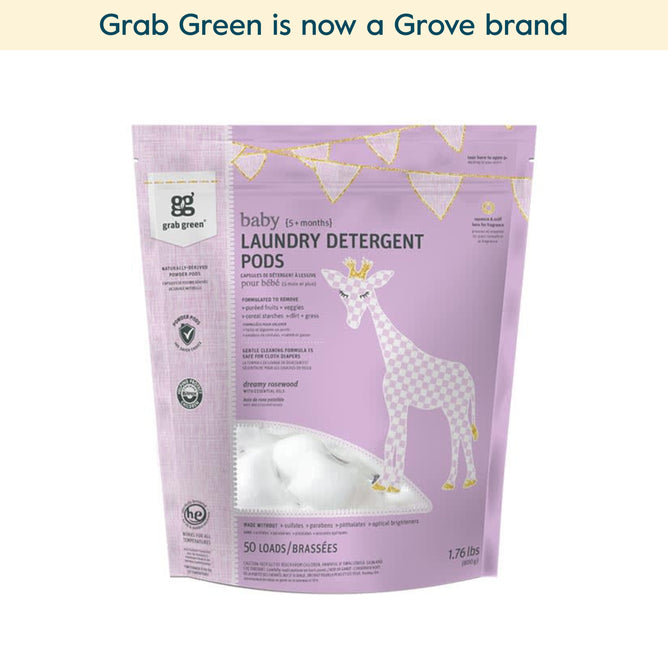 A lavender bag of grab green Baby Laundry Detergent Pods (5+ Months) (Coming Soon!) with a white and pink giraffe, gold bunting, and 50 loads label. Paraben-free, great for cloth diapers—now part of Grove brand. Net wt: 1.76 lbs.