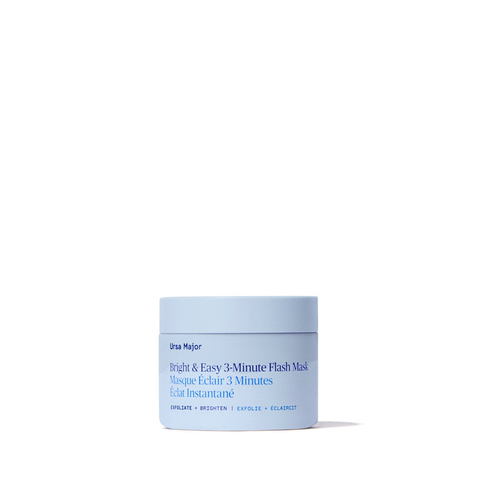 A light blue jar of Ursa Major Bright and Easy Flash Mask is centered on a white background, with a product label in blue text highlighting exfoliating, brightening, and skin tone evening benefits.