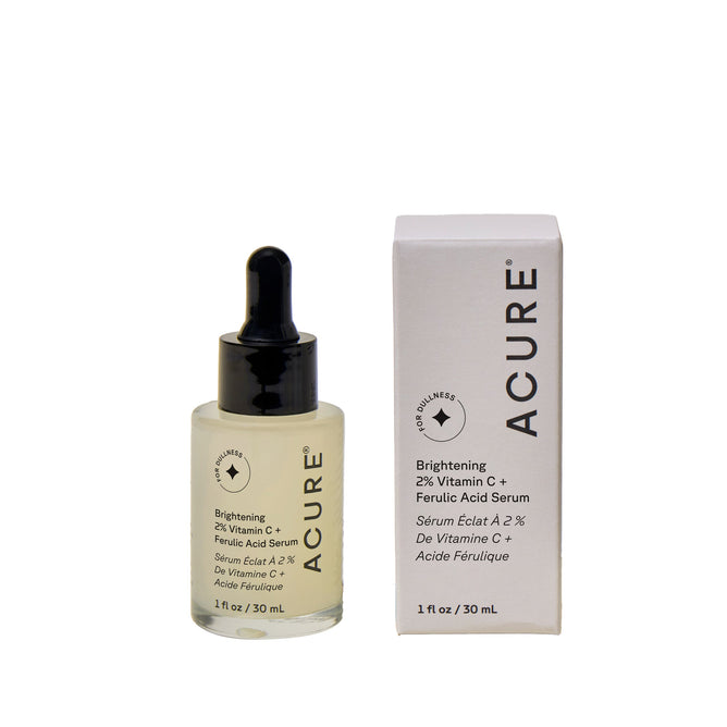 A 1 fl oz (30 mL) bottle of Acure Brightening Vitamin C & Ferulic Acid Serum with dropper sits beside its detailed box, both promoting luminous skin with vitamin C and ferulic acid.