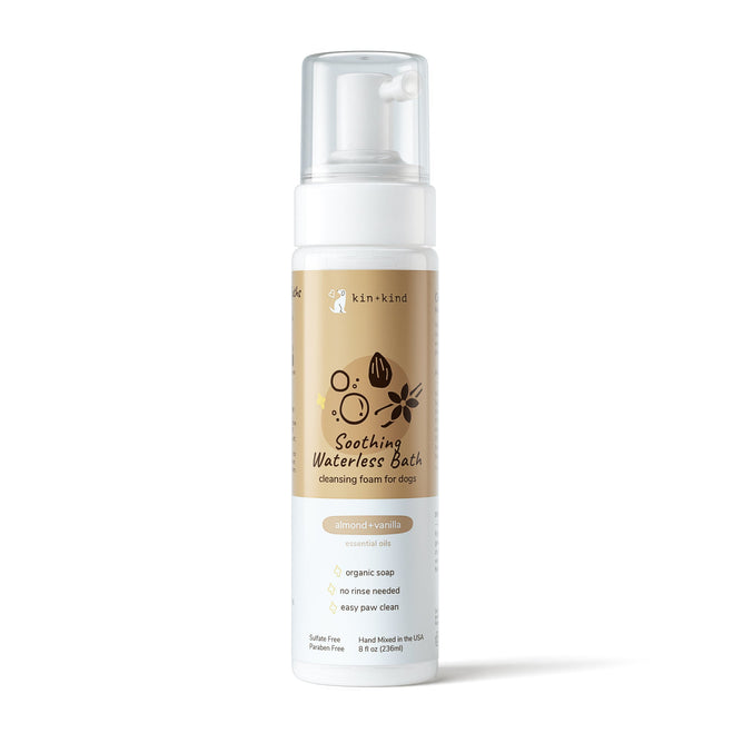 The kin+kind Soothing Waterless Bath for dogs is ideal for a rinse-free cleanse, featuring natural ingredients and an almond-vanilla scent. The beige label displays charming illustrations, and the bottle comes with a white pump.