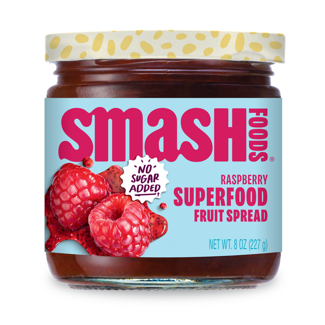 A jar of Smash Foods Superfood Jam - Raspberry with chia seeds, featuring raspberries on the label, red and blue text, a “No Sugar Added!” badge, and containing 8 oz (227 g) of delicious fruit spread.