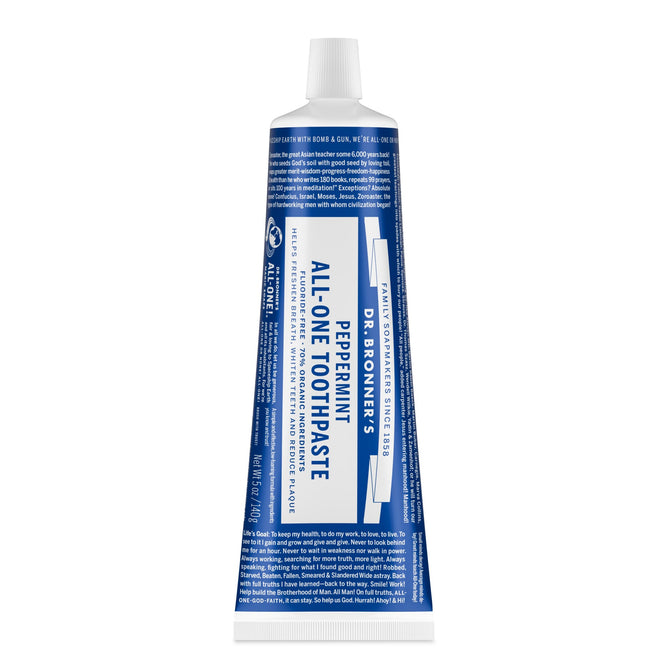 A blue and white tube of Dr. Bronners All-One Toothpaste stands upright with the cap on, displaying its label. This natural toothpaste is fluoride-free and features the Peppermint variety branding.