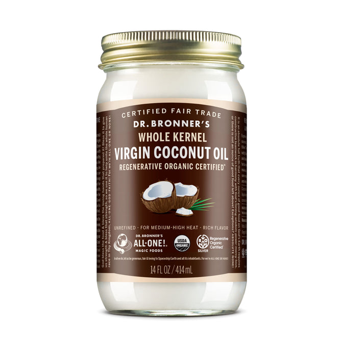 A jar of Dr. Bronners Fair Trade & Organic Whole Kernel Virgin Coconut Oil with a brown label showing coconut halves; the label notes this USDA certified oil is unrefined and fair trade.