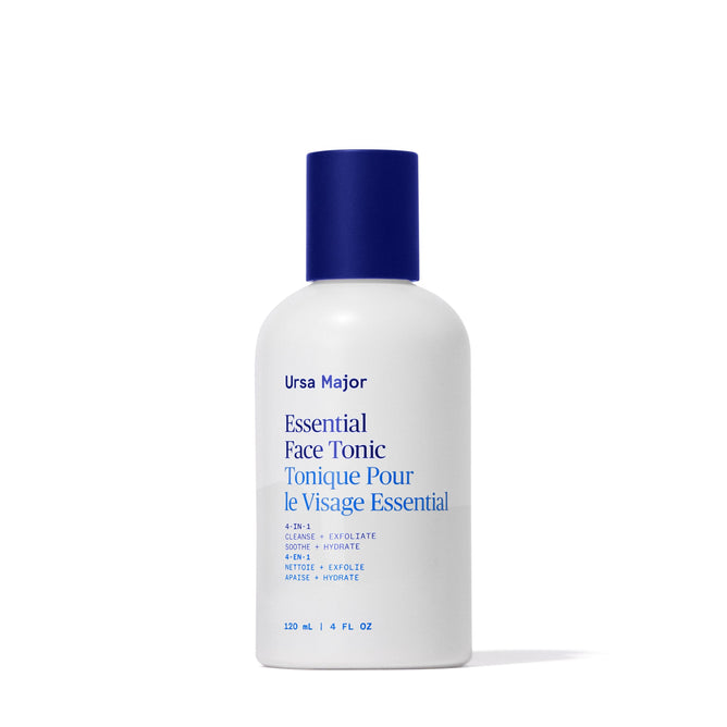 A white bottle with a blue cap labeled Ursa Major Essential Face Tonic in blue and black text, featuring English and French details. This 120 ml (4 fl oz) Ursa Major tonic gently exfoliates skin for a clearer complexion.