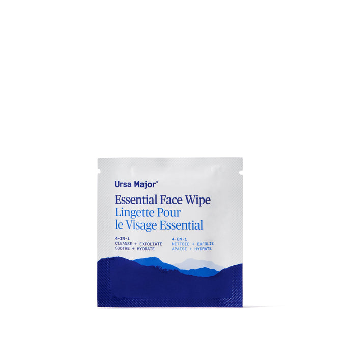 A single Ursa Major Essential Face Wipes packet features blue mountain graphics and bilingual “Essential Face Wipe”/“Lingette Pour le Visage Essential” text, highlighting clean ingredients on a white background.