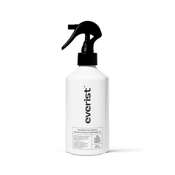A white spray bottle labeled Everist with a black trigger nozzle stands upright on a plain white background. The label reads The Body Oil Spritz and highlights nourishing Bakuchiol and Vitamin C for radiant skin.