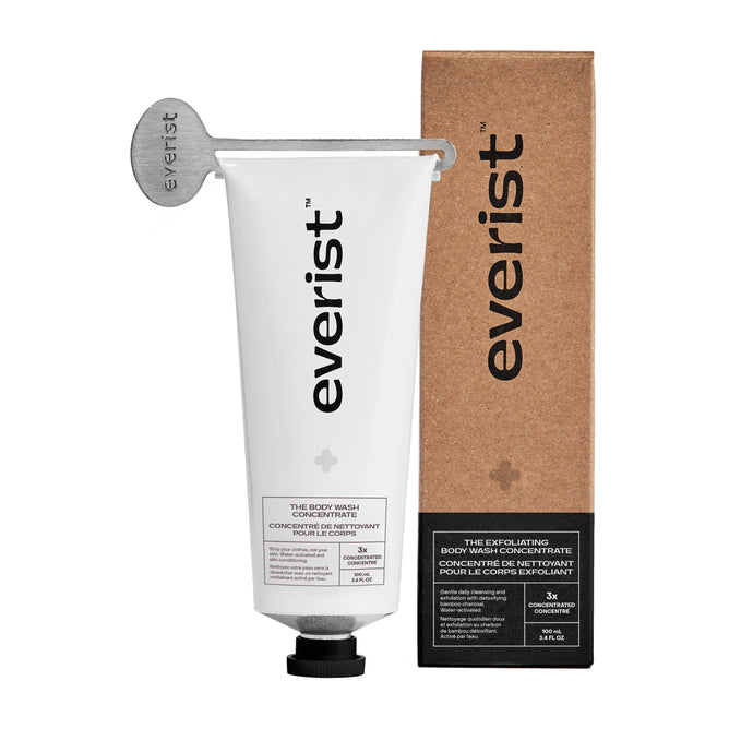 A white tube labeled Everist with a metal key sits beside a brown box featuring The Exfoliating Body Wash Concentrate—an effective body care product enriched with skincare ingredients.