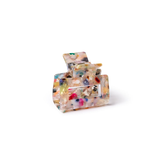 The Small Confetti Claw Clip by Everist is made from translucent resin with colorful confetti patterns and a visible metal spring. This gentle clip is ideal for daily styling, shown on a plain white background.