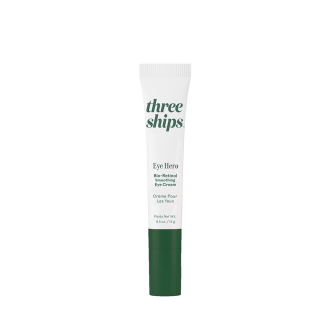A tube of Three Ships Eye Hero Bio-Retinol Smoothing Eye Cream, featuring a white cap and green base, stands upright on a plain white background—formulated to target fine lines and wrinkles.