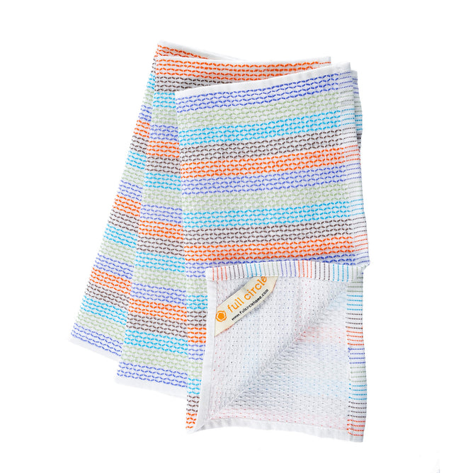 Two folded Tidy Dish Cloths by Full Circle feature horizontal stripes in orange, blue, and gray. Made from organic cotton with a textured scrubbing surface, they are suitable for kitchen use and dyed with non-toxic dyes. A tag displays the Full Circle name and logo.