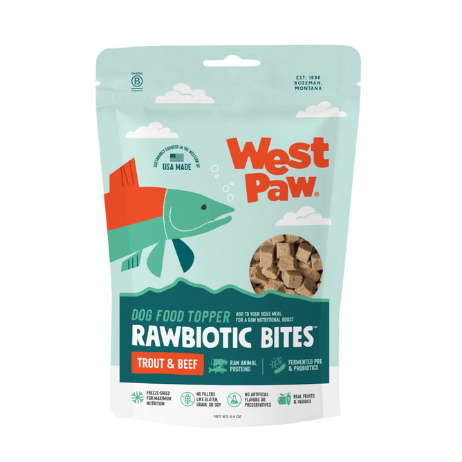 A turquoise and white bag of West Paw Trout & Beef Rawbiotic Bites Dog Food Topper with fermented probiotics and raw animal proteins. The package shows an illustrated fish, cube-shaped treats, and includes a USA-made label.