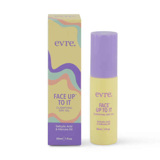 A 30ml bottle and box of evre. Face Up To It Clarifying Dry Oil, featuring a purple and yellow abstract wave design, blends salicylic acid with manuka oil for clearer skin.
