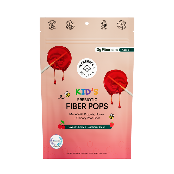 A sample pack of Beekeepers Naturals Kids Prebiotic Fiber Pops in Sweet Cherry Raspberry Blast, with two red lollipops on a pink gradient background, supports kids digestive health.