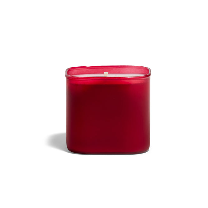 A red, square Grove Co. Candles 9.5oz from the Fall Collection sits unlit in a frosted glass container, crafted with eco-friendly ingredients and set against a plain white background.