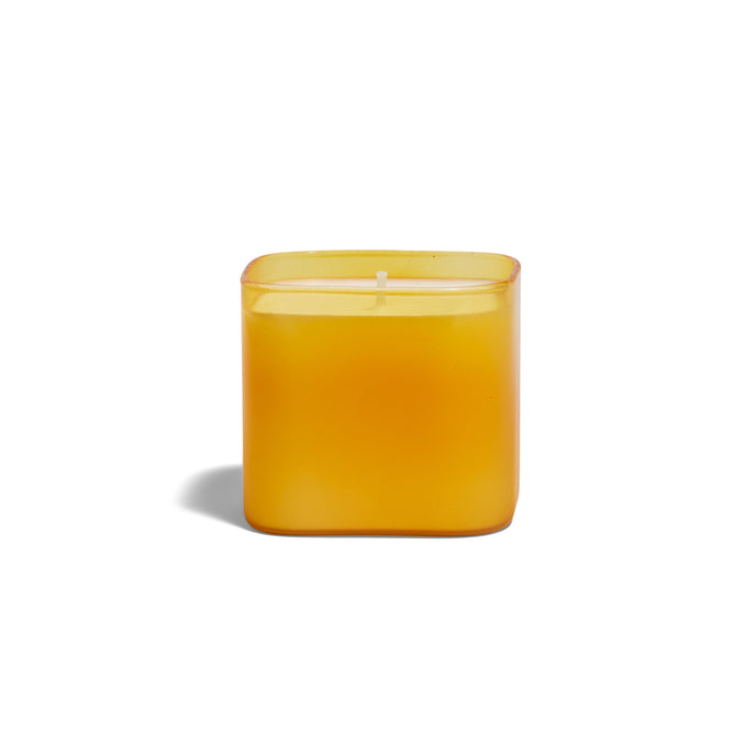 The Grove Co. Candle - Fall Collection, featuring a yellow square glass holder with a yellow candle, is displayed against a plain white background with a faint left shadow.