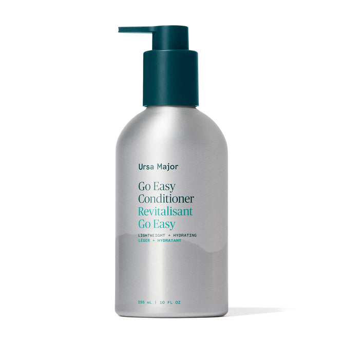 A 236 ml (8 fl oz) silver bottle with a teal pump labeled Ursa Major Go Easy Conditioner, a lightweight, hydrating conditioner for added shine and volume.