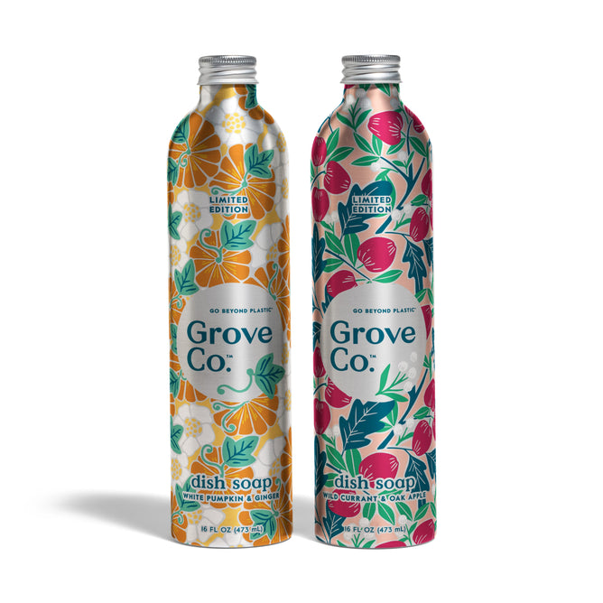 Two sustainable metallic bottles of Grove Co. Dish Soap Set - Fall Collection with floral designs stand side by side: orange and white on the left, pink and green on the right. Limited edition.