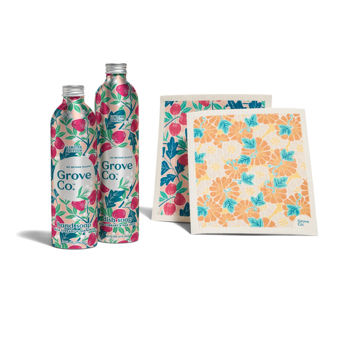 The Grove Co. Kitchen Essentials Set - Fall Collection features two colorful hand soap refill bottles with floral and fruit designs paired with two reusable cleaning cloths adorned in vibrant florals, all set against a plain white background.