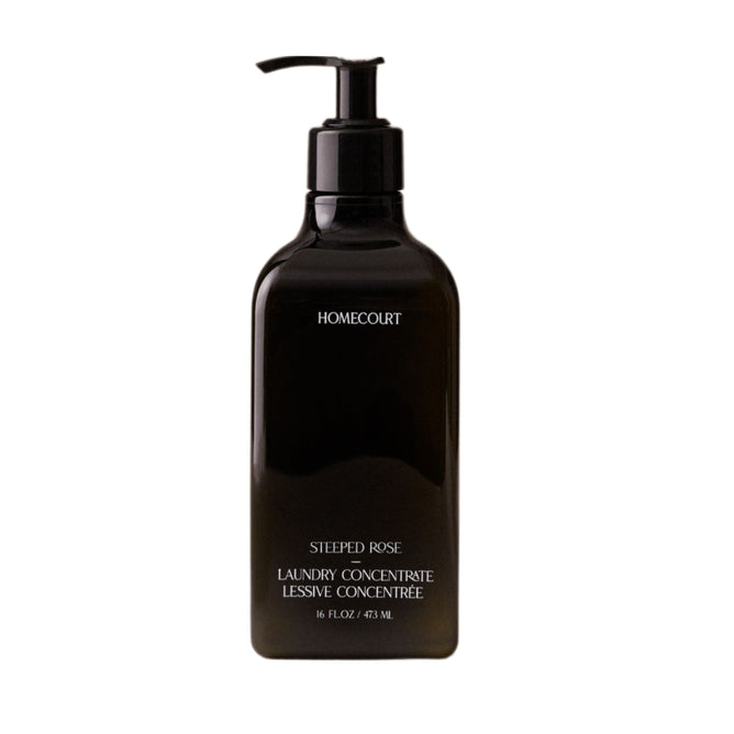 A black pump bottle of Homecourt Laundry Concentrate, 16 fl oz/473 ml, with plant-based, eco-friendly cleaning agents is shown against a white background.