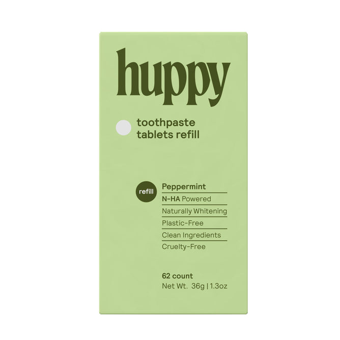 A green box of Huppy Toothpaste Tablets Refill, peppermint flavor. Features natural teeth whitening with N-HA, clean ingredients, cruelty-free, plastic-free packaging, and 62 tablets per box.
