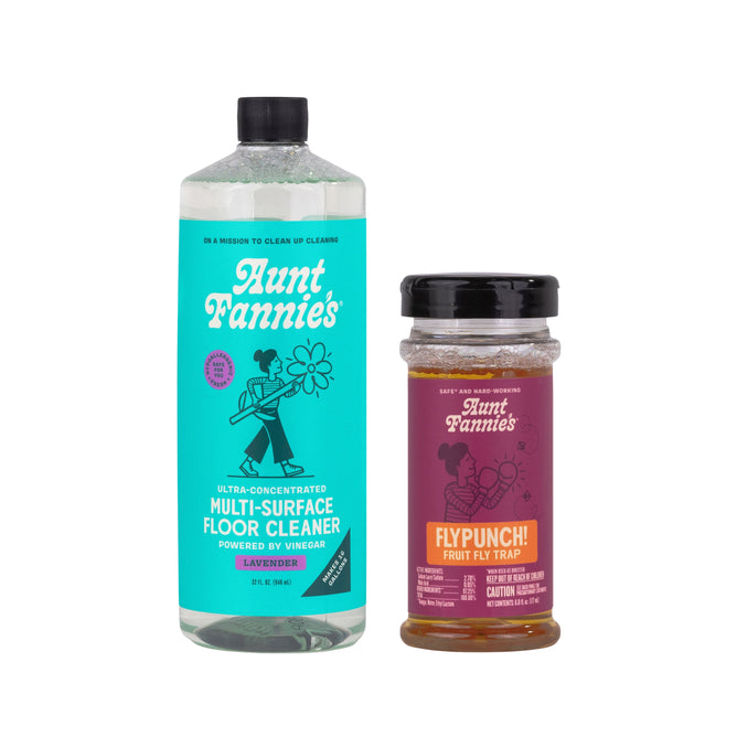 A Grove Collaborative Multi-Surface Floor Cleaner + free gift stands beside a jar of FlyPunch! fruit fly trap, both with colorful labels on a white background.