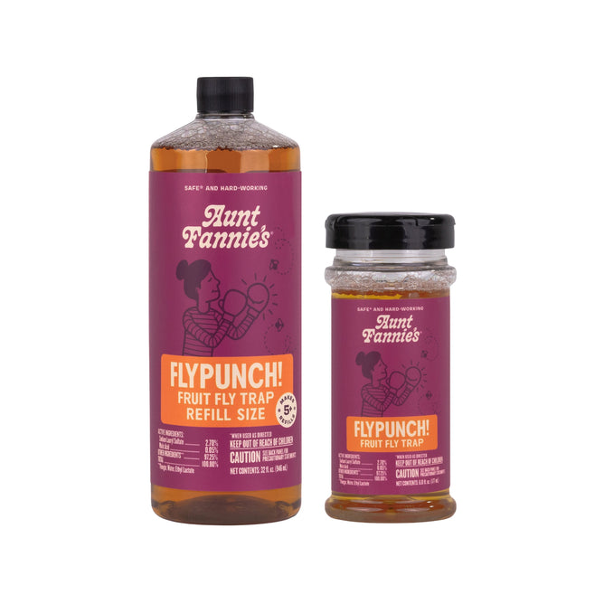 Two bottles of Aunt Fannies FlyPunch! Fruit Fly Trap Refill + free gift are shown side by side—both with purple labels and orange accents, offering a smart, eco-friendly way to cut down on plastic use.