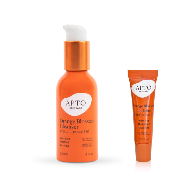 Explore two skincare must-haves from APTO Skincare: the Orange Blossom Cleanser with Grapeseed Oil and a coconut-infused lip balm. Both showcase white labels and bold orange packaging, reflecting simple elegance.