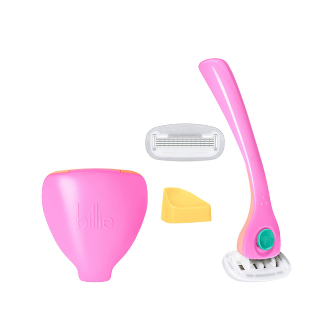 The billie Razor + Travel Case includes a pink handle with a white and green detachable blade, a yellow holder, an extra blade, and a pink case labeled billie—all shown on a white background.