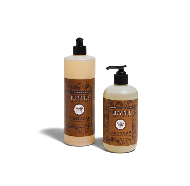 Two bottles of Mrs. Meyers Crisp & Clean Sinkside Set - Acorn Spice, including dish soap and hand soap with brown labels, are displayed on a white background.