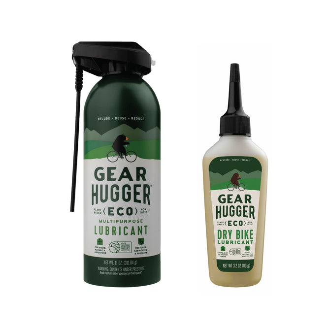 Two Gear Hugger lubricant bottles are shown: a larger green bottle labeled as a non-toxic Multi-Purpose Lubricant with spray nozzle featuring a cyclist silhouette, and a smaller eco-friendly dry bike lubricant with an applicator tip, both promoting sustainability.