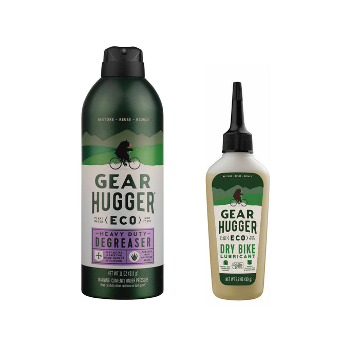 Image of two eco-friendly Gear Hugger bike maintenance products: a spray can of plant-powered Heavy Duty Degreaser + free gift on the left, and a squeeze bottle of Dry Bike Lubricant on the right. Both feature green packaging with cyclist and mountain graphics, showcasing their non-toxic solution.
