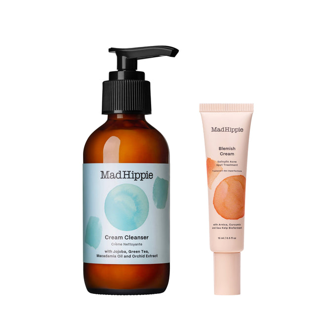 Two Mad Hippie products—a brown pump bottle of Cream Cleanser + free gift with a blue label and a beige tube of Blemish Cream with an orange circle—stand upright on a white background.