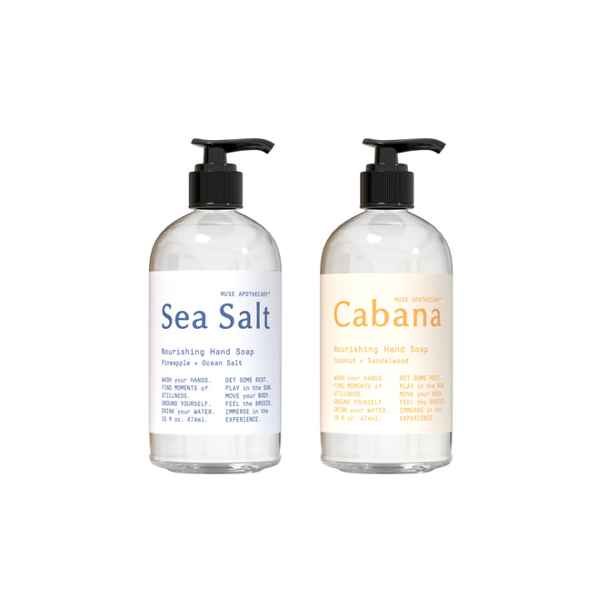 Two bottles of Muse Apothecarys Nourishing Hand Soap with pumps: the left is Sea Salt (Pineapple + Ocean Salt), and the right is Cabana (Coconut + Sandalwood). Both have clear bottles and minimalist typography on their labels. Includes a free gift.